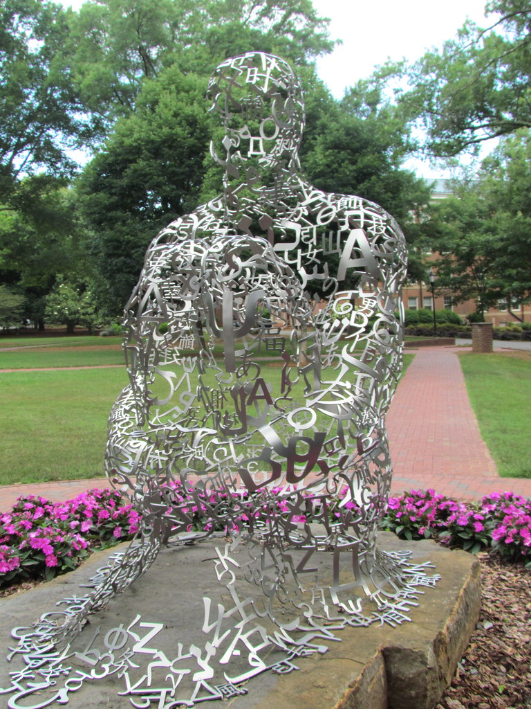 Metal humanoid sculpture with Davidson college in the background